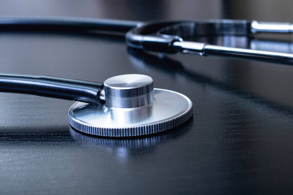 Medical stethoscope on a black table close up