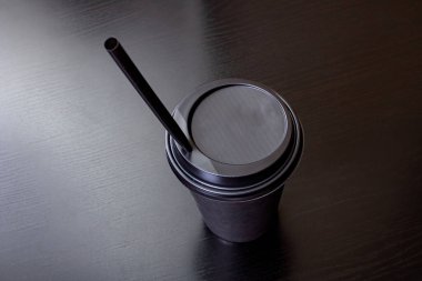 Tahta bir masada izole edilmiş siyah bir kahve fincanı.