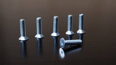 Tahta bir arka planda sıralanmış cıvatalar