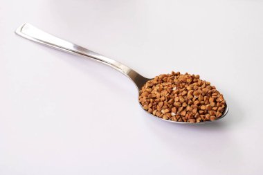 Karabuğday gri arka planda bir kaşıkta inliyor