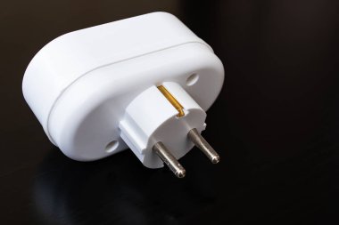 Siyah ahşap bir masa üzerindeki Tee outlet prizi.