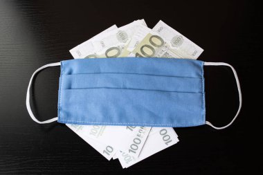 100 Euro 'luk banknotlar ve tıbbi maske.