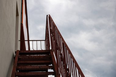 Binanın çatısına çıkan metal merdivenler kasvetli gökyüzünde