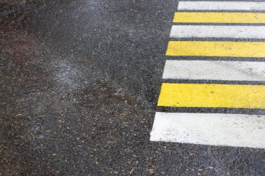 Asfalt ve yaya geçidinde yağmur damlaları yakın plan