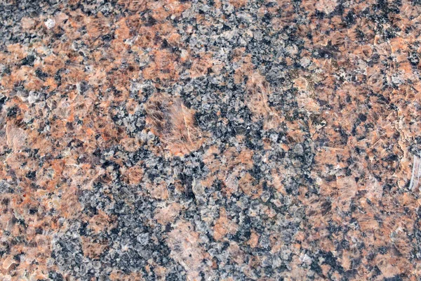 Bright red black granite stone close up, background or texture
