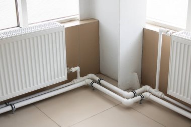 Pencerenin yanındaki borular ve radyatörler kapalı.