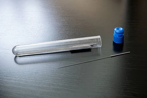 Long thin needles in a test tube — Stock Photo, Image