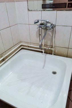 Ucuz bir kapanışta küçük bir duş odası.