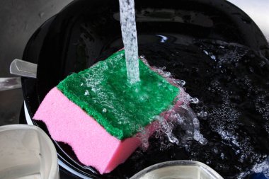 Lavaboda bulaşıklar ve süngerler. Kapatın.