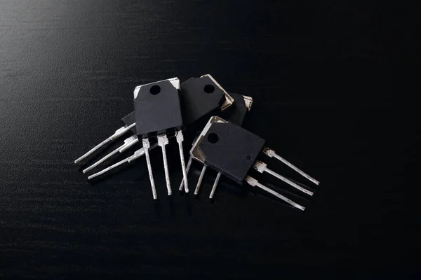 Schwarze Transistoren Auf Einem Schwarzen Holztisch Großaufnahme — Stockfoto