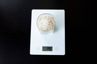 Ahşap bir masada, üzerinde pirinç bulunan cam.