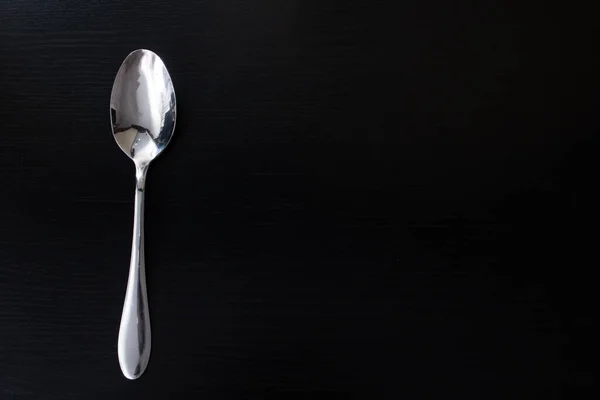 Metal Spoon Black Wooden Table Closeup Copy Space — Stock Photo, Image