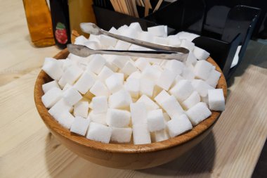 Masadaki tahta kasede küp şekerler.