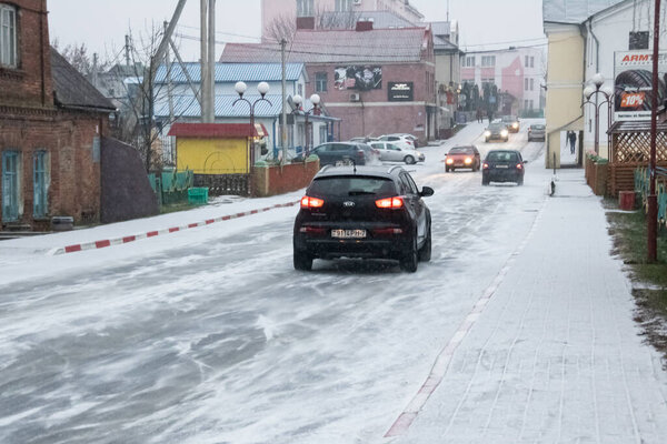 BELARUS, POSTAVY - OCTOBER 10, 2019: Snowy road and cars in city