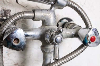 Beyaz bir duvarda paslı su musluğu. Yaklaş.