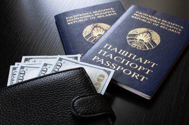 Beyaz Rusya pasaportu ve para dolarları ahşap masaya yakın.