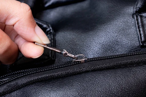 Hand fastening the zip on the bag close up