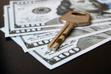 Siyah bir masada dolar ve anahtar.