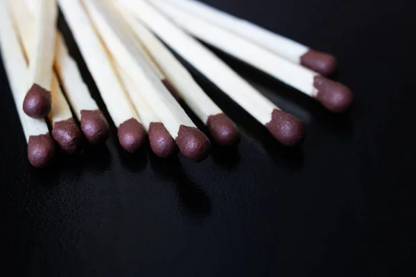 Tumpukan korek api di atas meja kayu hitam — Stok Foto