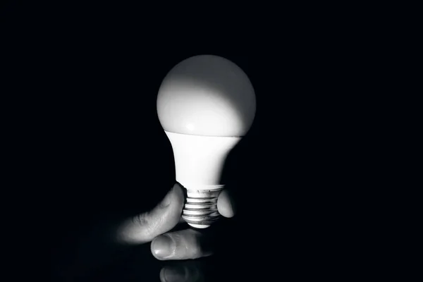 Light bulb in hand in the dark — Stock Photo, Image