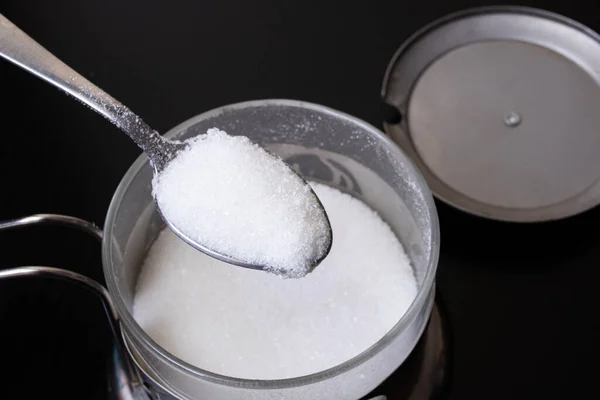 Sugar in a spoon by the can — Stock Photo, Image
