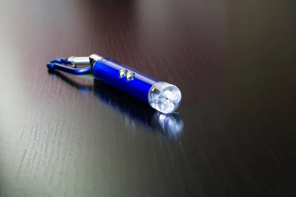 Blue laser pointer on a wooden background