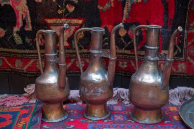 Sarı arka plan üzerinde eski bakır su ibrik