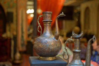 Eski vintage bakır kukuletalı sürahi. Sarı arka plan üzerinde eski bakır su ibrik