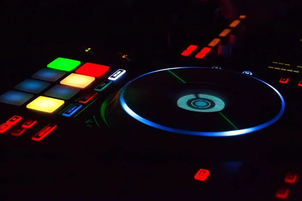 DJ's hands are busy mixing electronic music on the console. The DJ music must be played to the audience. DJ have to be able to use very good control buttons. The confetti is used to enhance the party