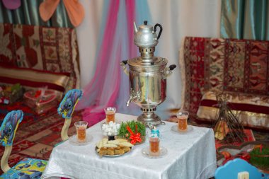 Semeni vintage plaka üzerinde dekore edilmiştir. Semaver ve çaydanlık. Semaver Novruz tatil bir arka plan üzerinde. Masa örtüsü bardak çay