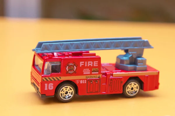 Red toy fire truck Toy fire engine extinguishes flaming house. Careless handling of fire dangerous for life