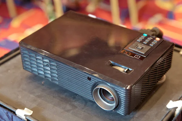 Close up projector in conference room . LCD Projector technology video presentation and home Entertainment object . mini led projector on wood table in a room projector home theater idea and concept.