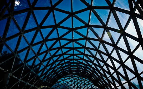 glass roof of a modern building and blue sky . Triangle aluminum alloy structure of glass and metal concave and curving wall of modern abstract building.