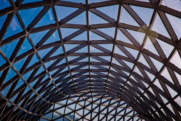glass roof of a modern building and blue sky . Triangle aluminum alloy structure of glass and metal concave and curving wall of modern abstract building.