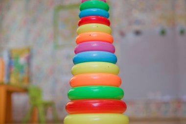 Eğitici oyuncaklar izole sarı halkalar, sürükleyici küçük bebekler için. Yığılmış dairesel bloklar renkli piramidi. Piramit kurmak--dan izole sarı arka plan üzerinde renkli plastik halkalar.