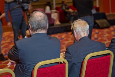 insanları kontrol için belgili tanımlık mezartaşı ile kel güvenlik görevlisi. bir konferans tartışma hararetli tartışmalara