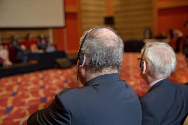 秃头保安带着耳机控制人 在一次会议讨论中激烈的辩论 — 图库照片