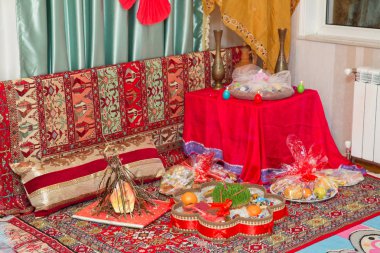 Novruz tepsi plaka Azerbaycan Ulusal pasta pakhlava ve shekerbura ile mor İpek eşarp. Azerbaycan Ulusal pasta pakhlava ve shekerbura ve yeşil semeni Novruz bakır tepsi plaka