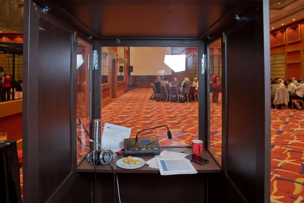Çevirmenler odacık. yorumlama - mikrofon ve geçiş panosunda bir simultane tercüman booth. Yumuşak odak kablosuz konferans mikrofonlar ve not defterinde bir toplantı salonu.
