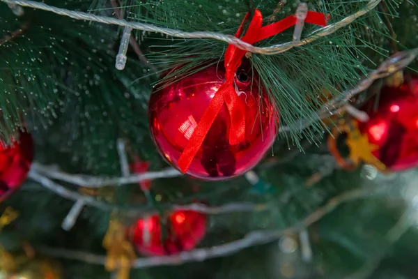 red and gold ball hangs on the background of a clock. It\'s time for a new year. Multicolored glare and brilliance. Gold box