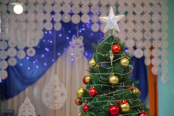 Winter holiday concept, decorated Christmas tree in the interior. Christmas concept interior room . Joyful studio shot of a Christmas tree with colorful ornaments .