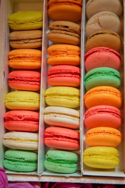 Noel lezzetli yiyecek. Kağıt kutusu ile Fransız tatlı - macaroons şenlikli süslemeli gri beton masada. Fransız lezzetli tatlı macaroons masada. Renkli macarons kek .