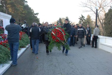 Bakü, Azerbaycan - Azerbaycan'ın başkenti vatandaşların katliamın yıldönümünde Bakıda, 20 Ocak Anıtı, mermer mezar üzerinde yas tutanlar tarafından açıdan koydu Ocak 20 2009 çiçekler