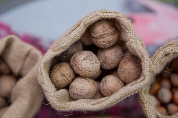 Walnoten in een klein tasje van containers. Close-up van walnoten als achtergrond. Mix van hazelnoot met harde shell. Gedroogd en walnoten, close-up — Stockfoto