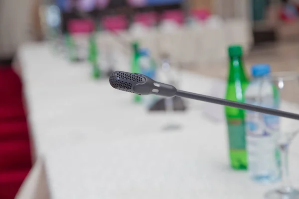 Conference hall or seminar room background to ready for indoor business conference . close up of a microphone on white background with clipping path . Starting the conference concept