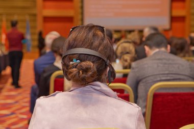 Kulaklık Konferansı'nda olan adam. Seyirci giyen baş telefon online çeviri için. Tanınmayan insanlar olay sırasında çeviri için kulak kulaklık kullanarak