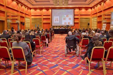 Grup iş adamları basın toplantısı veya sunuyu katılıyor. Engelli iş adamı. Devre dışı işadamı işkadını konferans salonunda dizüstü bilgisayar ile yakın oturan Olgun