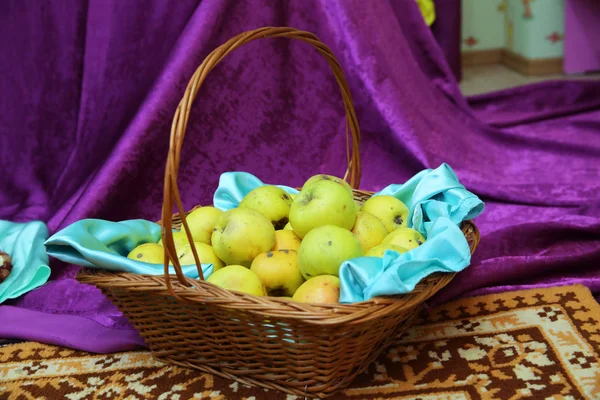 Gelber und grüner Apfel im Korb. Korb mit grünen Äpfeln, auf denen schwarze Punkte und Spuren von Würmern zu sehen sind. saftige grüne Äpfel in einem Weidenkorb. Reichliche Ernte. Früchte im Weidenkorb — Stockfoto