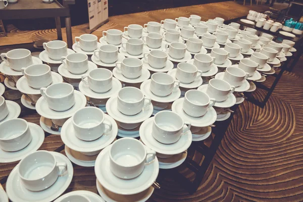 Close up dirty coffee cup and spoon setting on white saucer and wooden table after drinking in the morning in vintage style. — Stock Photo, Image