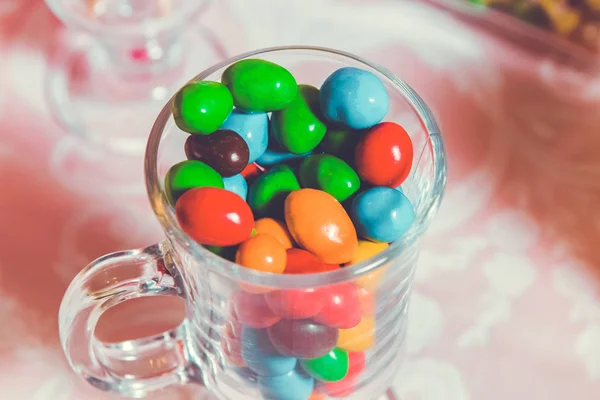 Bonbons colorés. Bonbons multicolores. Bonbons colorés dans un verre. Chocolat rond est très coloré — Photo